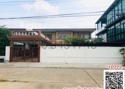 Exterior view of a two-story house with a gated entrance