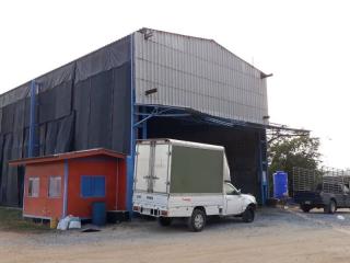 Exterior view of an industrial warehouse with a white truck parked outside