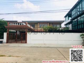 Exterior view of a residential building with gated entrance and driveway