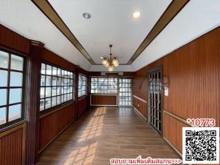 Spacious living room with wooden paneling and large windows