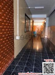 Tiled corridor with decorative brick wall inside a residential building