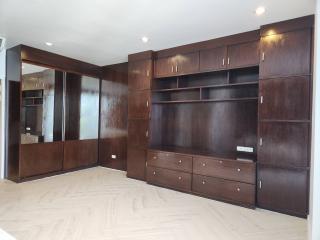 Spacious living room with built-in wooden shelving and cabinetry