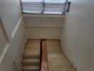 Modern wooden staircase with natural light coming through the window