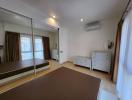 Spacious bedroom with mirror wardrobe and air conditioning unit