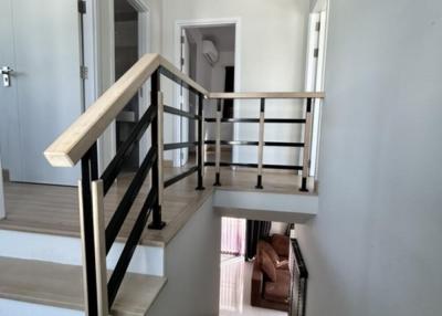 Modern staircase design with sleek metal railings and wooden handrails leading to upper level