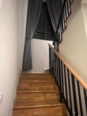 Wooden staircase with black bannisters inside a home