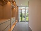Modern bedroom wardrobe with open walk-in closet leading to a garden