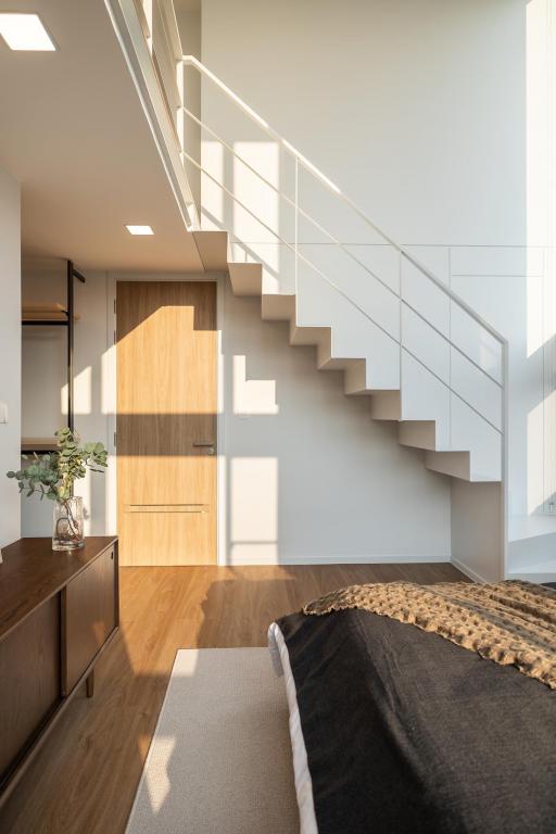 Modern bedroom with natural light and staircase
