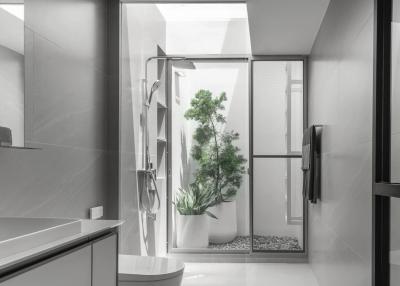 Modern bathroom interior with a glass shower and green plants