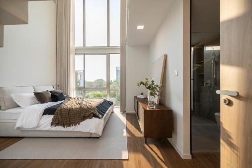 Spacious modern bedroom with large windows and an en-suite bathroom