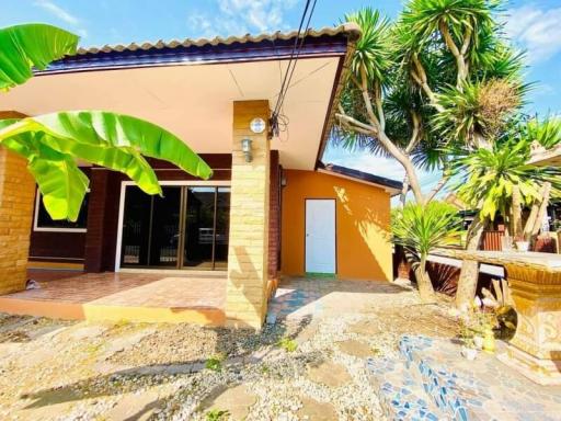 Cozy single-story house with a terracotta roof and tropical landscaping