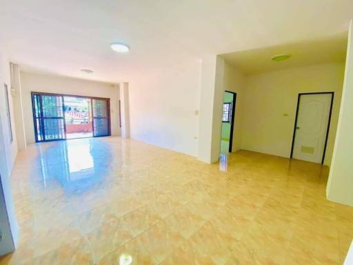 Spacious and bright living room with tiled flooring and multiple doors