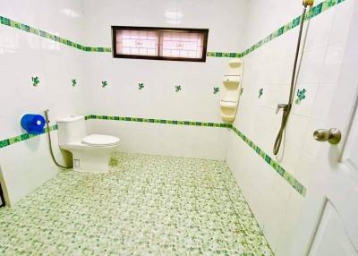 Spacious bathroom with green tile accents and natural light