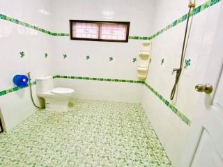 Spacious bathroom with green tile accents and natural light