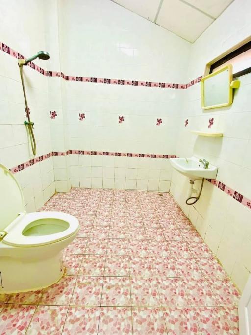 Spacious bathroom with white tiles and floral patterns