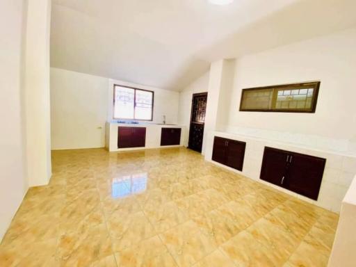 Spacious and bright kitchen with tiled flooring and wooden cabinets