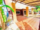 Spacious and well-lit home exterior with carport and terracotta tiles