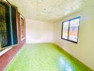 Empty bedroom with green tiled floor and large window