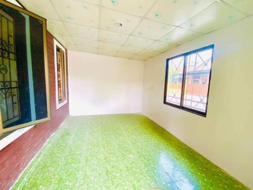 Empty bedroom with green tiled floor and large window