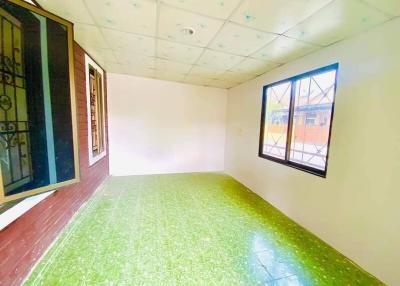 Empty bedroom with green tiled floor and large window