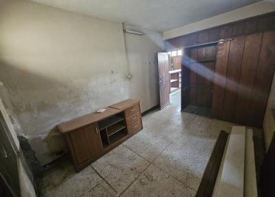 Spacious but poorly maintained room with tiled floor and wooden cabinet