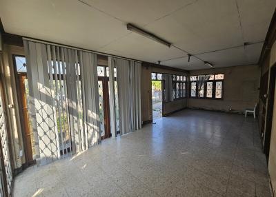 Spacious living room with large windows and tile flooring