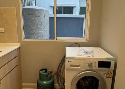 Compact laundry room with LG washing machine and a large window