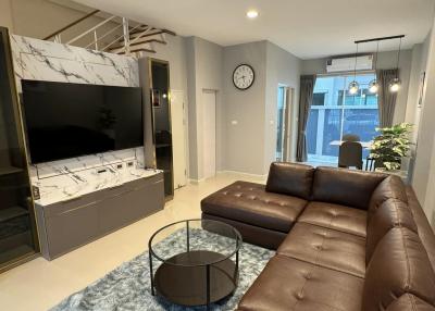 Modern living room with large leather sofa and flat-screen TV