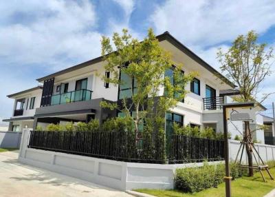 Modern two-story house with a landscaped front yard and clear blue skies