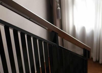 Modern wooden staircase with metal balusters and natural light