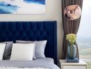 Modern bedroom with blue velvet headboard and stylish bedding