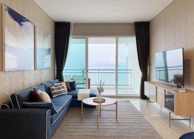 Modern living room with ocean view, featuring stylish furniture and large windows