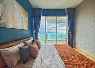 Cozy bedroom with ocean view and balcony access