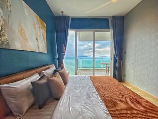 Cozy bedroom with ocean view and balcony access