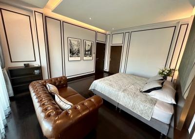 Elegant bedroom with leather sofa and comfortable bed