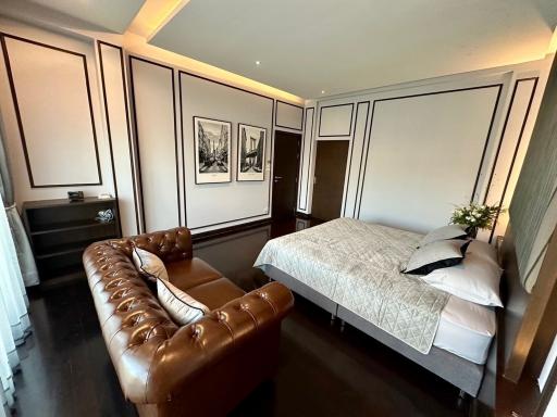 Elegant bedroom with leather sofa and comfortable bed