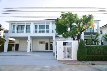 Modern two-story house with balcony and a neatly paved driveway