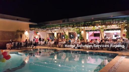 Poolside Party Area with Guests and Festive Lighting