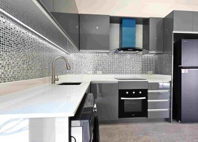 Modern kitchen with stainless steel appliances and mosaic backsplash