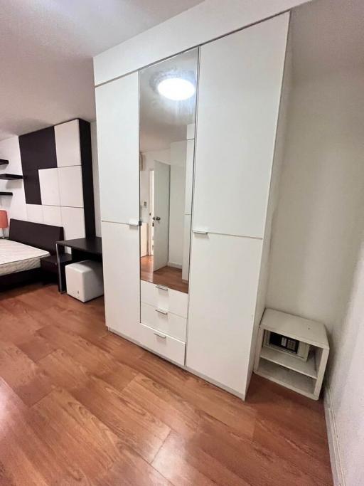 Modern bedroom with large mirrored wardrobe and parquet flooring