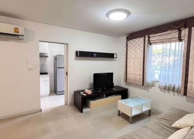 Modern living room with neutral tones, equipped with furniture and a flat-screen TV