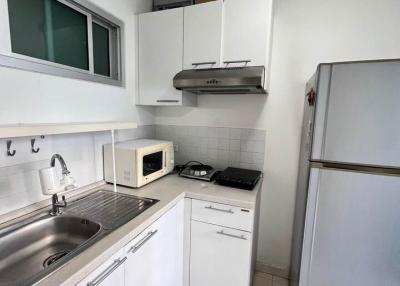 Compact, well-equipped kitchen with modern appliances and white cabinetry