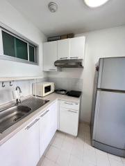 Compact, well-equipped kitchen with modern appliances and white cabinetry