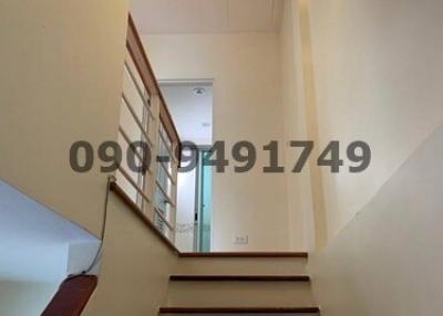 Bright staircase with wooden steps leading to upper level of a home