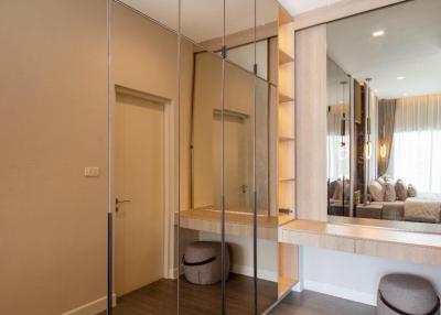 Elegant bedroom with mirrored wardrobe and view into cozy living area