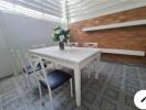 Cozy dining area with a white table and chairs, patterned tile flooring, and wooden accent wall