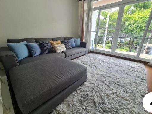 Spacious living room with large sectional sofa and floor-to-ceiling windows