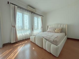 Spacious and well-lit bedroom with large window and elegant furnishings
