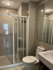 Modern bathroom with glass shower and beige tiles