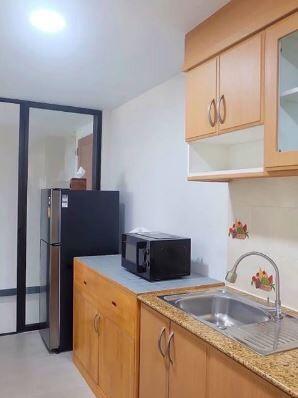 Compact modern kitchen with wooden cabinets and stainless steel sink